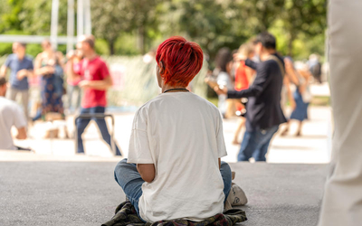 Jeune assise par terre écoutant de la musique pour Kiosque en fete au Jardin Nelson Mandela 