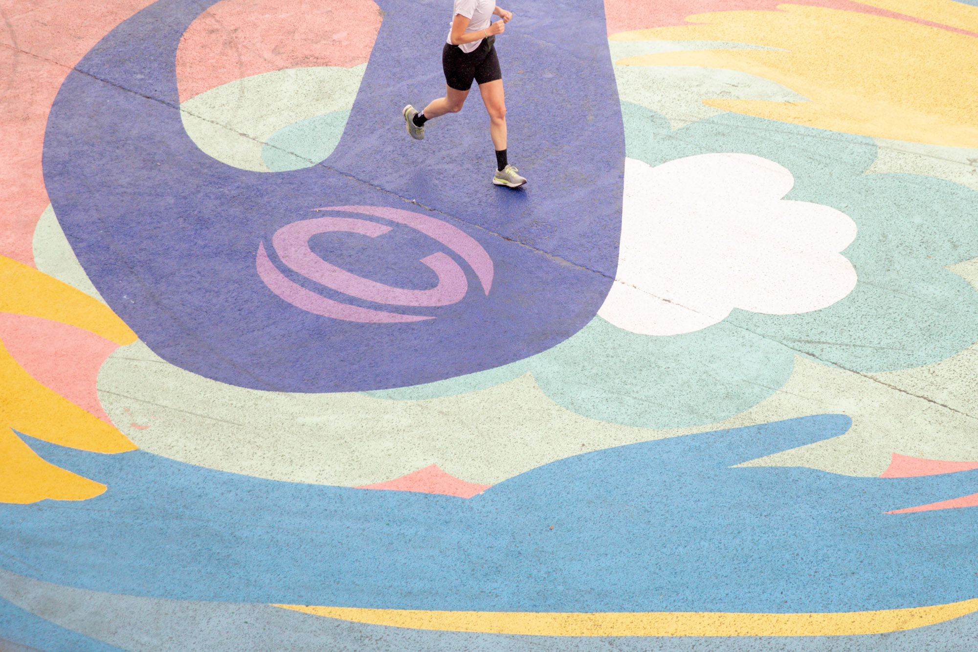 Un coureur foulant le sol de la fresque ASICS sur le quai de Seine. 