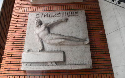 Ronde bosse sur la facade du stade Pierre de Coubertin représentant un gymnaste sur un agrès