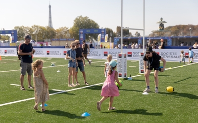 des enfants et leurs parents en train de jouer au rugby sur de l'herbe 