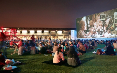 des gens assis regardant un film sur un grand écran 