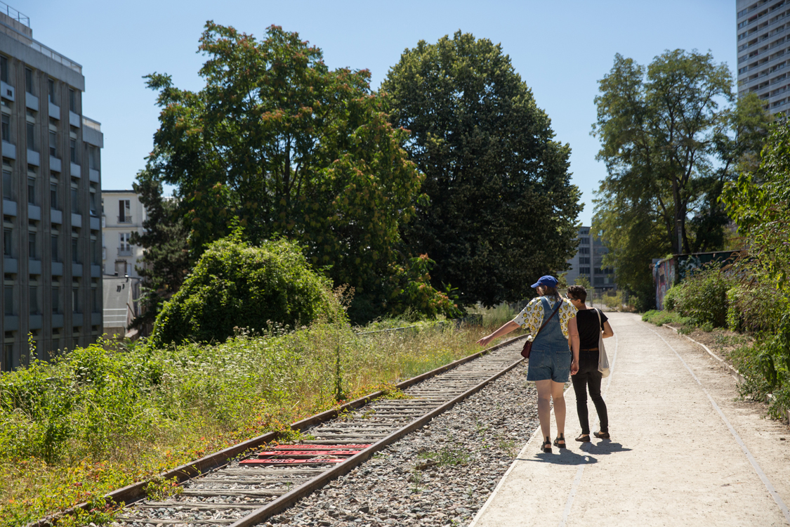 Deux personnes se promenent le long de la Petite Ceinture.  