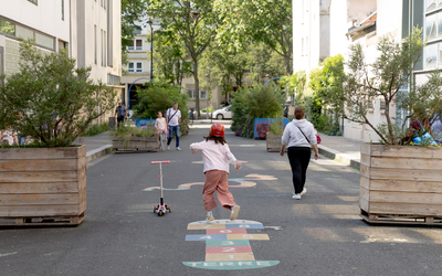 Une enfant jouant à la marelle dans une rue aux écoles du 19e. 