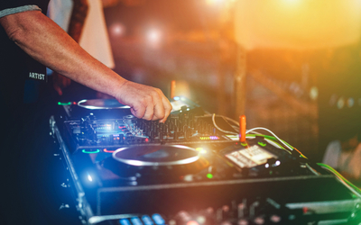 A man mixes on a turntable under neon lights