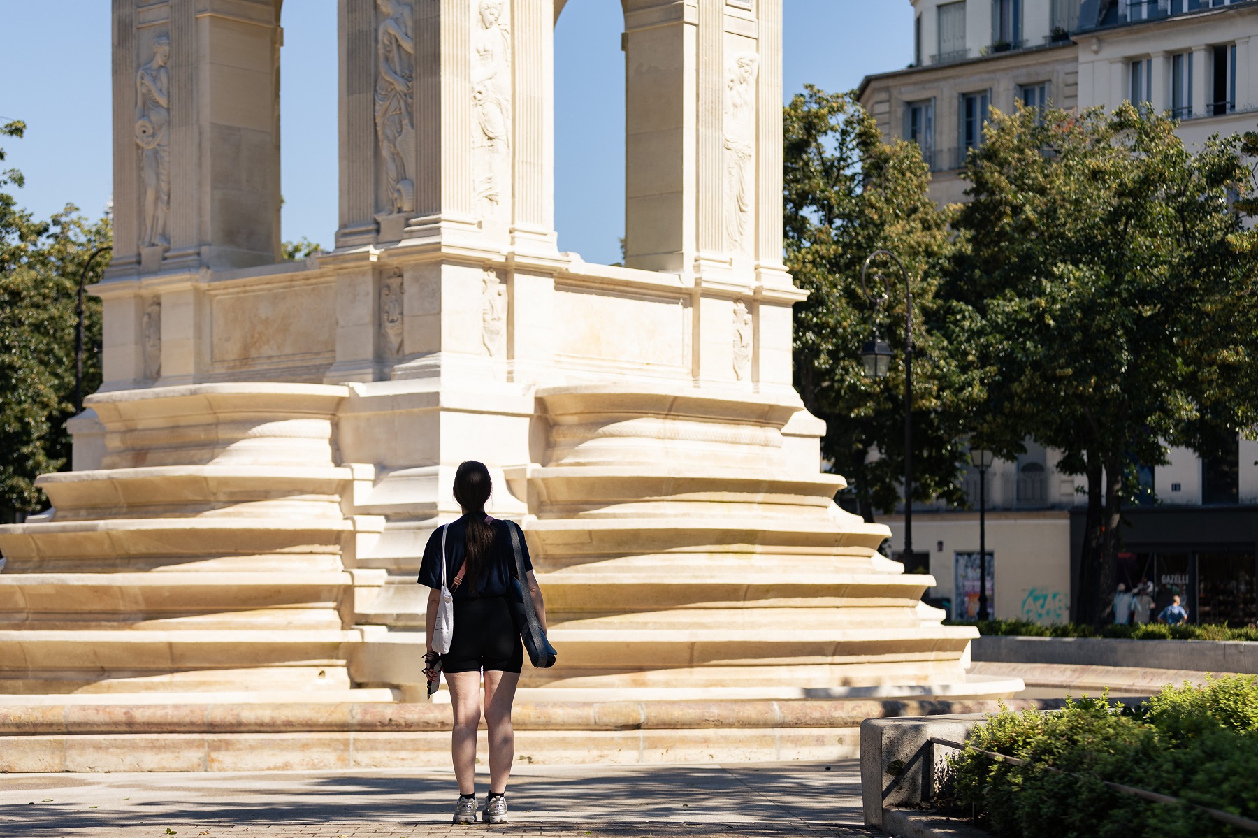 Une personne se tient devant la fontaine rénovée