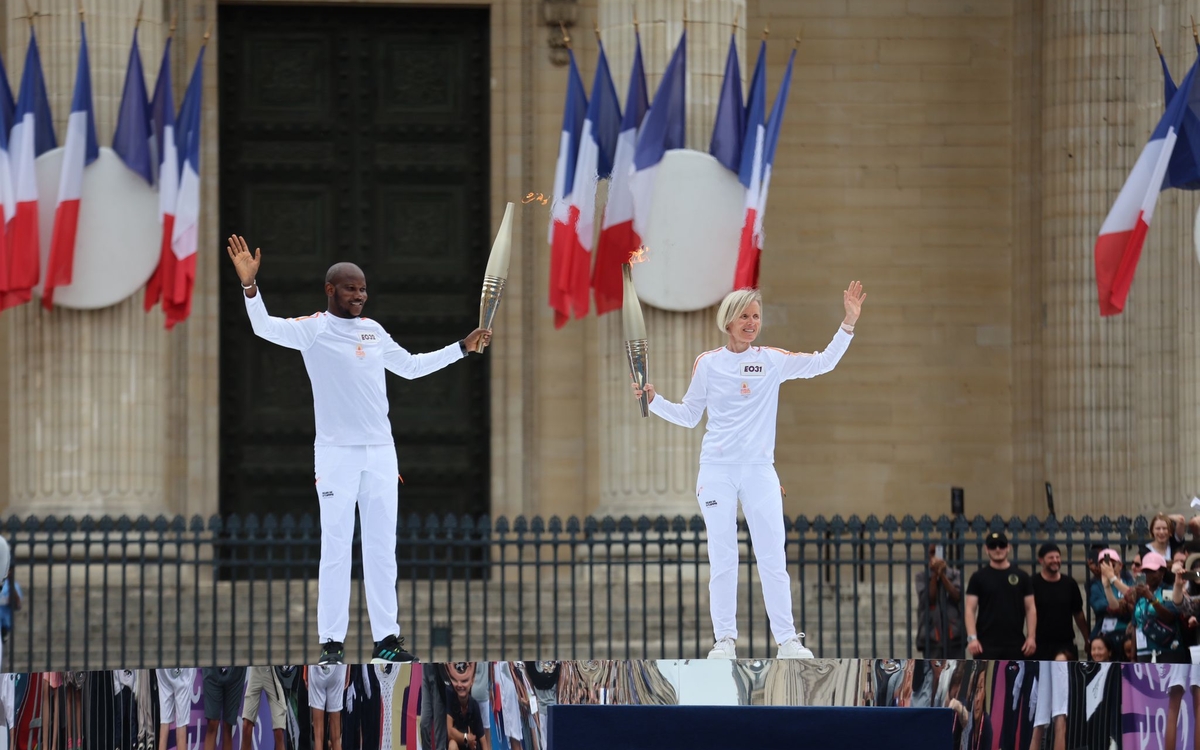 Photo of AP-HP nurse anesthetist Claudine Laslaz and Lassana Bathily, one of the heroes of the hyper kosher attack, hand over the Olympic flame in front of the Panthéon.