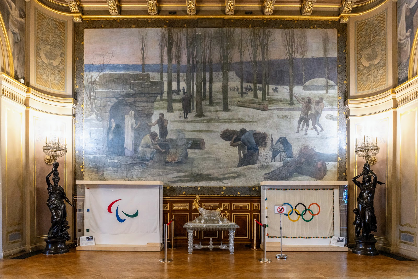 Sous le tableau de Puvis de Chavannes, la nef entourée des anneaux olympiques et des agitos