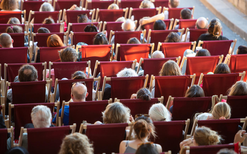 Personnes installées sur transat en plein air pour regarder un film