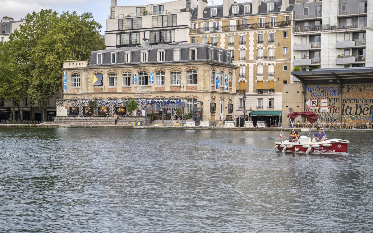 Un bateau passe devant la maison des Canaux