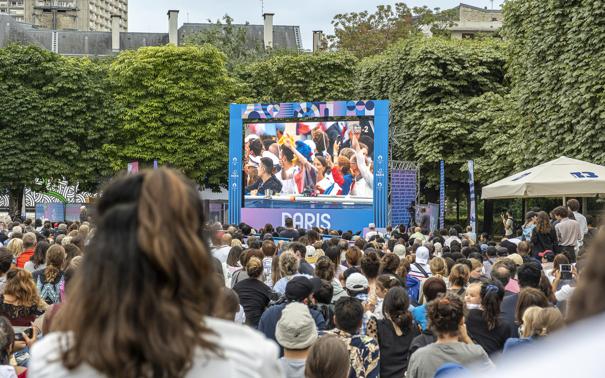 Une foule  sur le site de festivités du 13e, au parc de Choisy regarde sur écran géant la retransmission de la cérémonie d'ouverture des JO. 