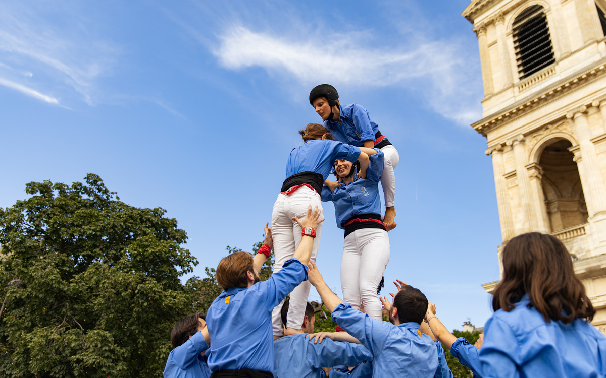 Quatre personnes portent deux portent sur leurs épaules qui tiennent une autre personne