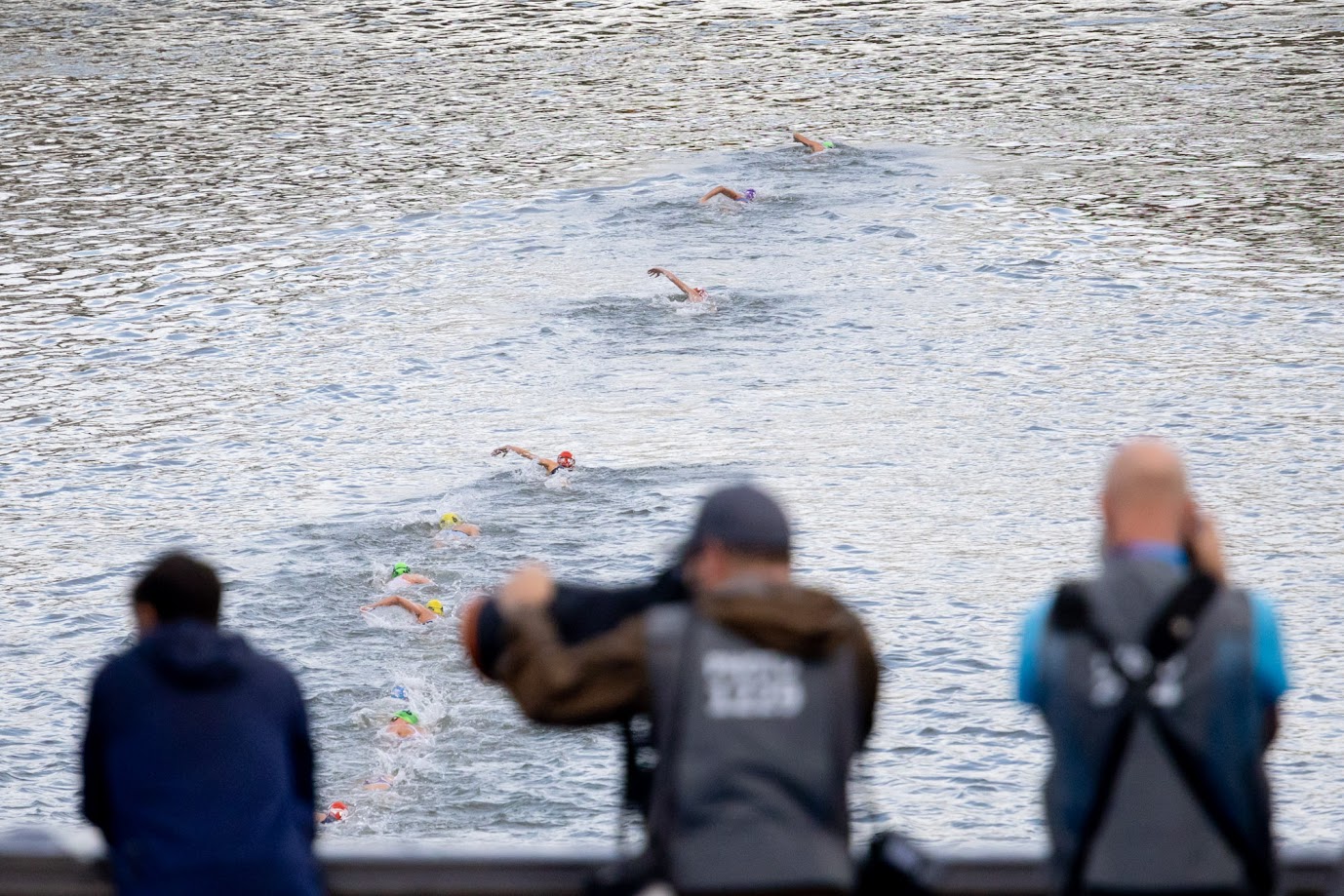 Des photographes immortalisent les triathlètes dans la Seine.