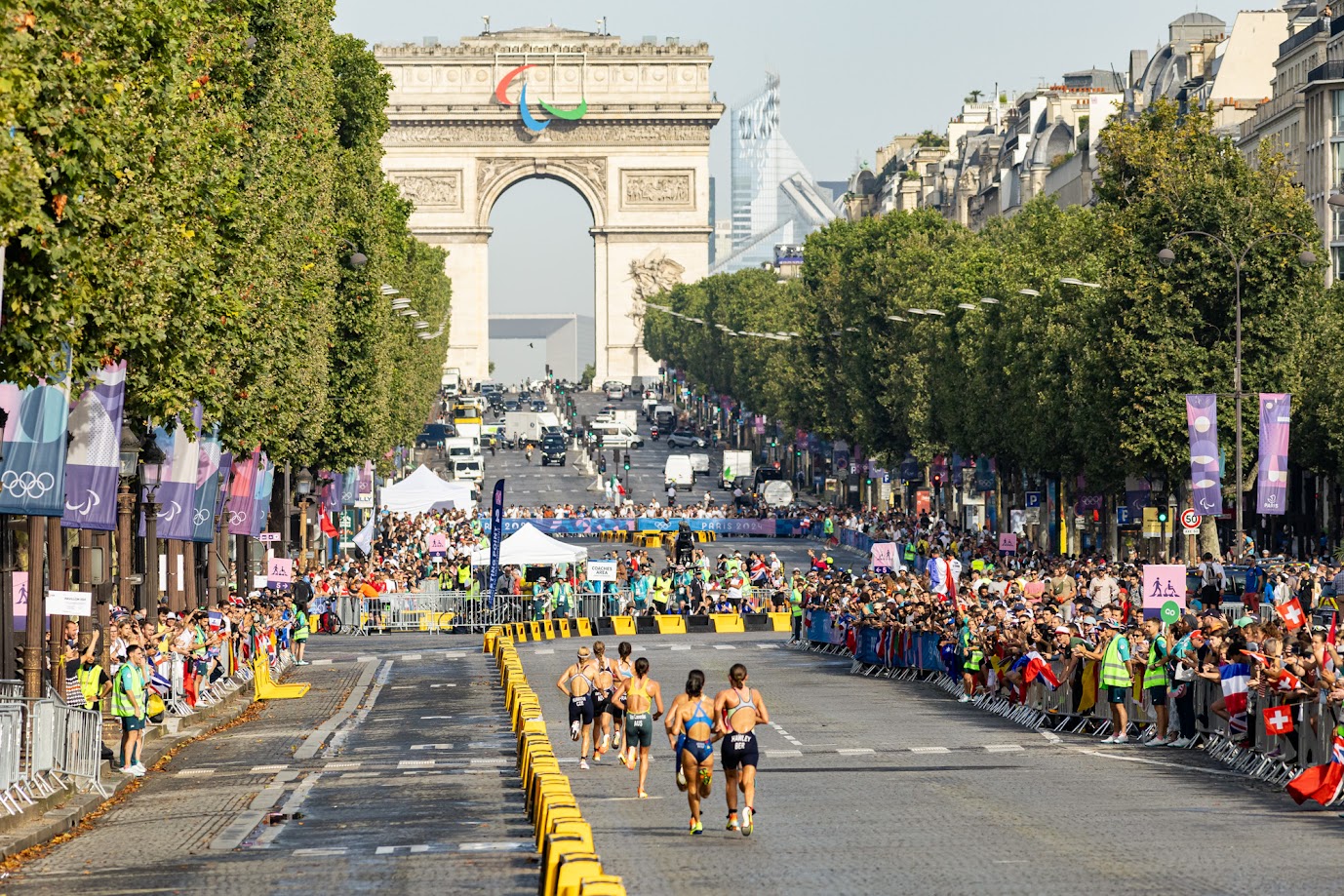 Arrivée des triathlètes sur les Champs-Elysées, avec l'Arc de Triomphe en arrière-plan.