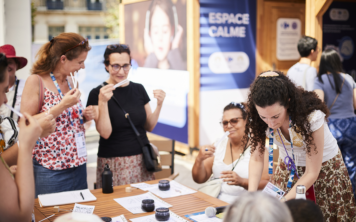 Des participantes sentent des fragrances lors d'un atelier olfactif sur la terrasse des jeux.