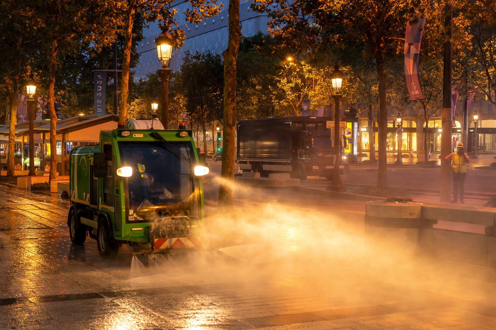 Un véhicule de la mission propreté nettoie le trottoir des Champs-Elysées