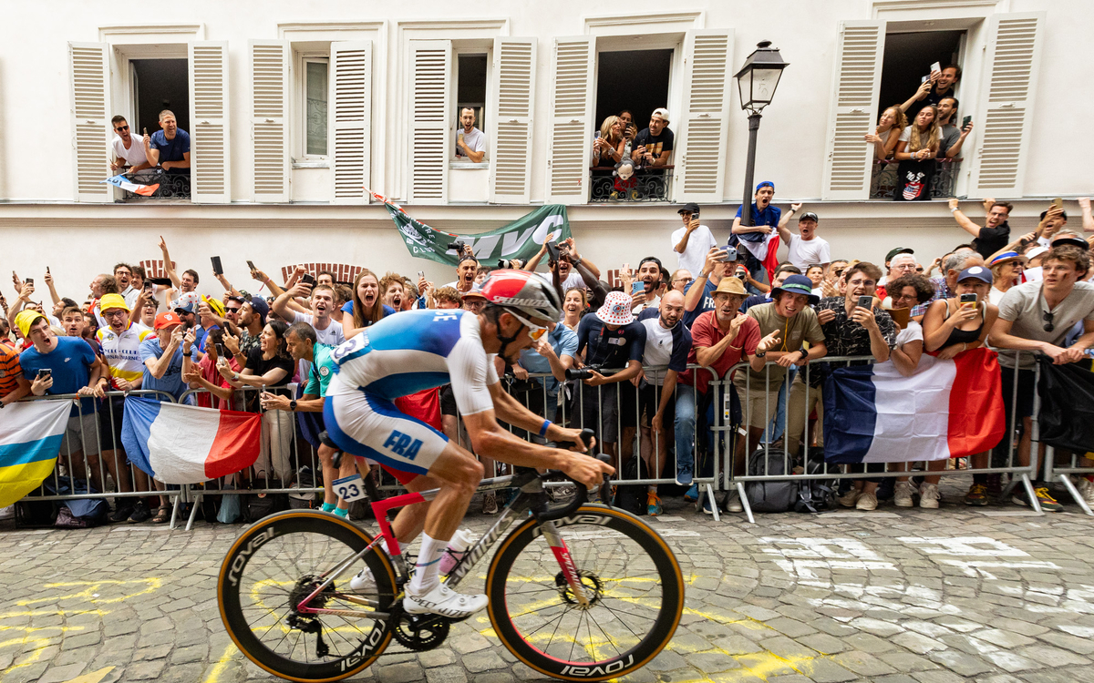 Un cycliste français passe devant une foule qui crie pour le soutenir.