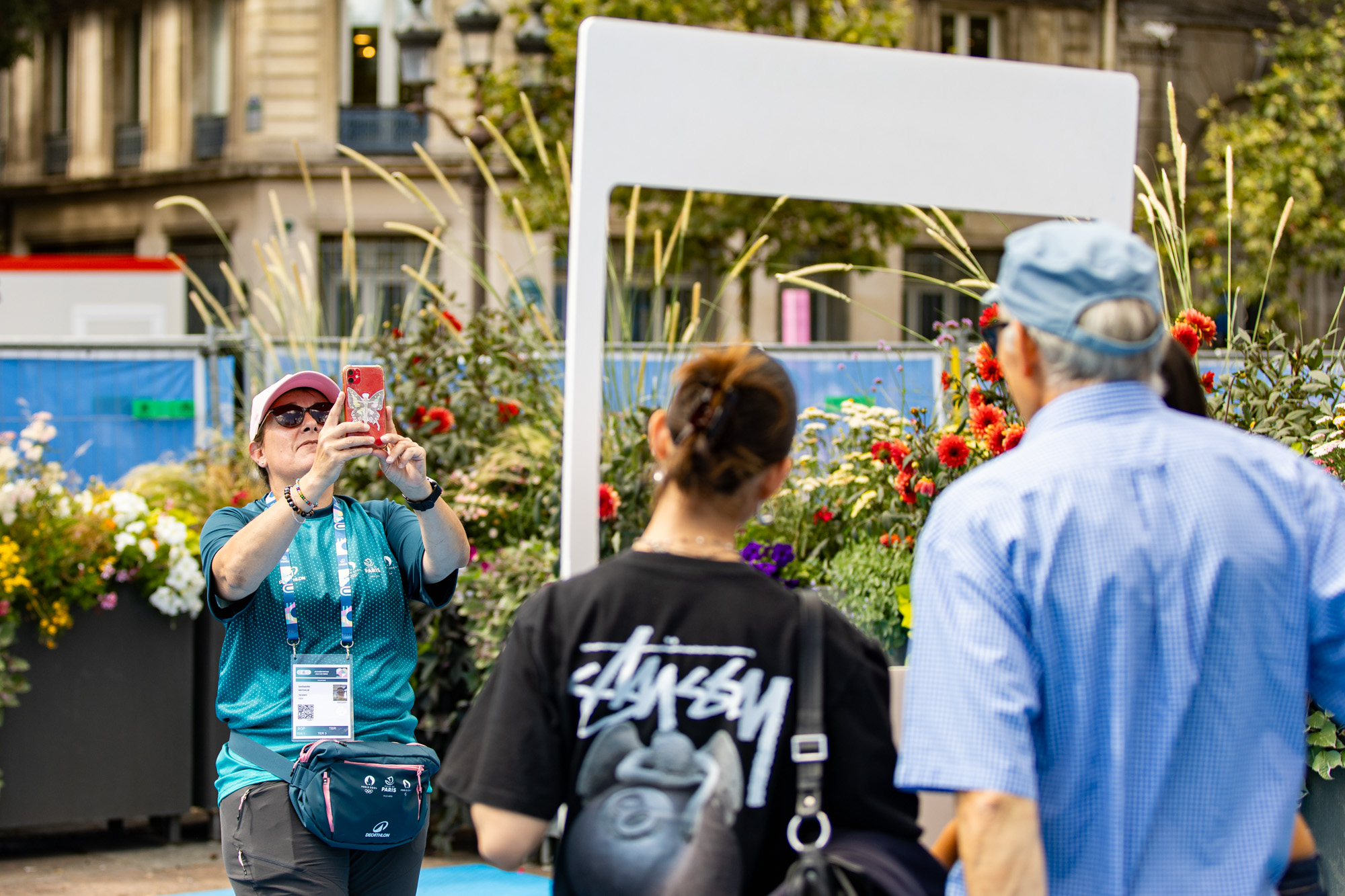 Une volontaire prend une photo de touristes dans un cadre