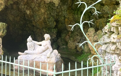 Statue en pierre d'une nymphe dans une grotte.