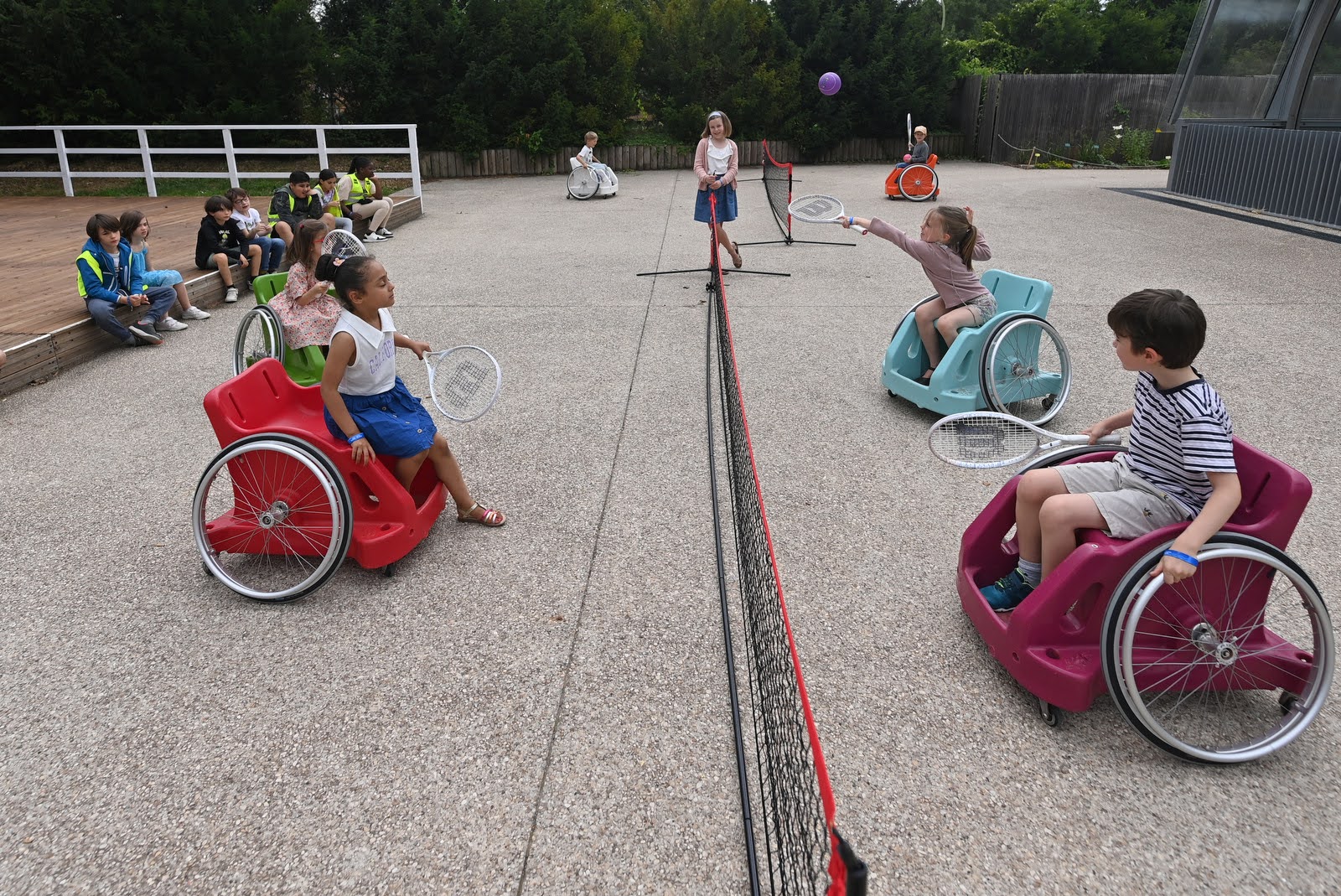Des écoliers testent le tennis en fauteuil roulant adapté