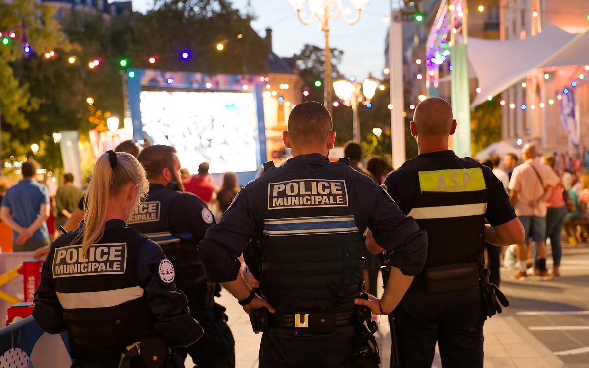 Plusieurs policiers de dos devant l'écran