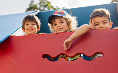 Trois enfants souriants dans un centre de loisirs