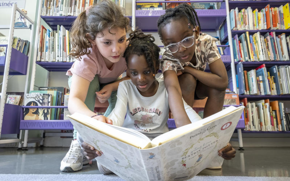 Trois fillettes regardant un livre