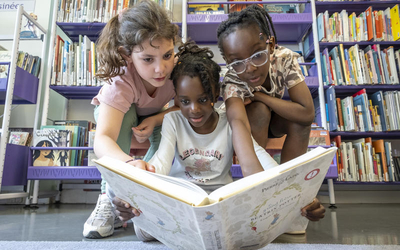 Trois fillettes regardant un livre