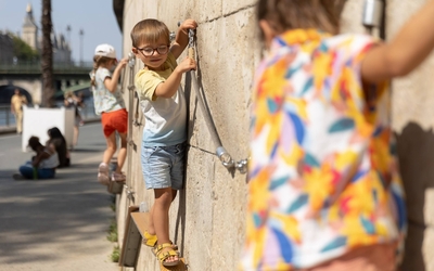 des enfants qui jouent le long d'un mur sur une corde 