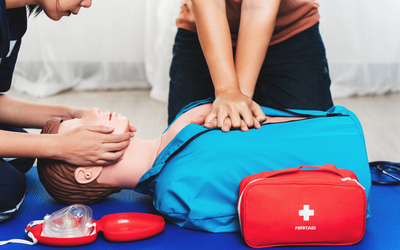 Des personnes en train d'effectuer les premiers soins à un mannequin. 