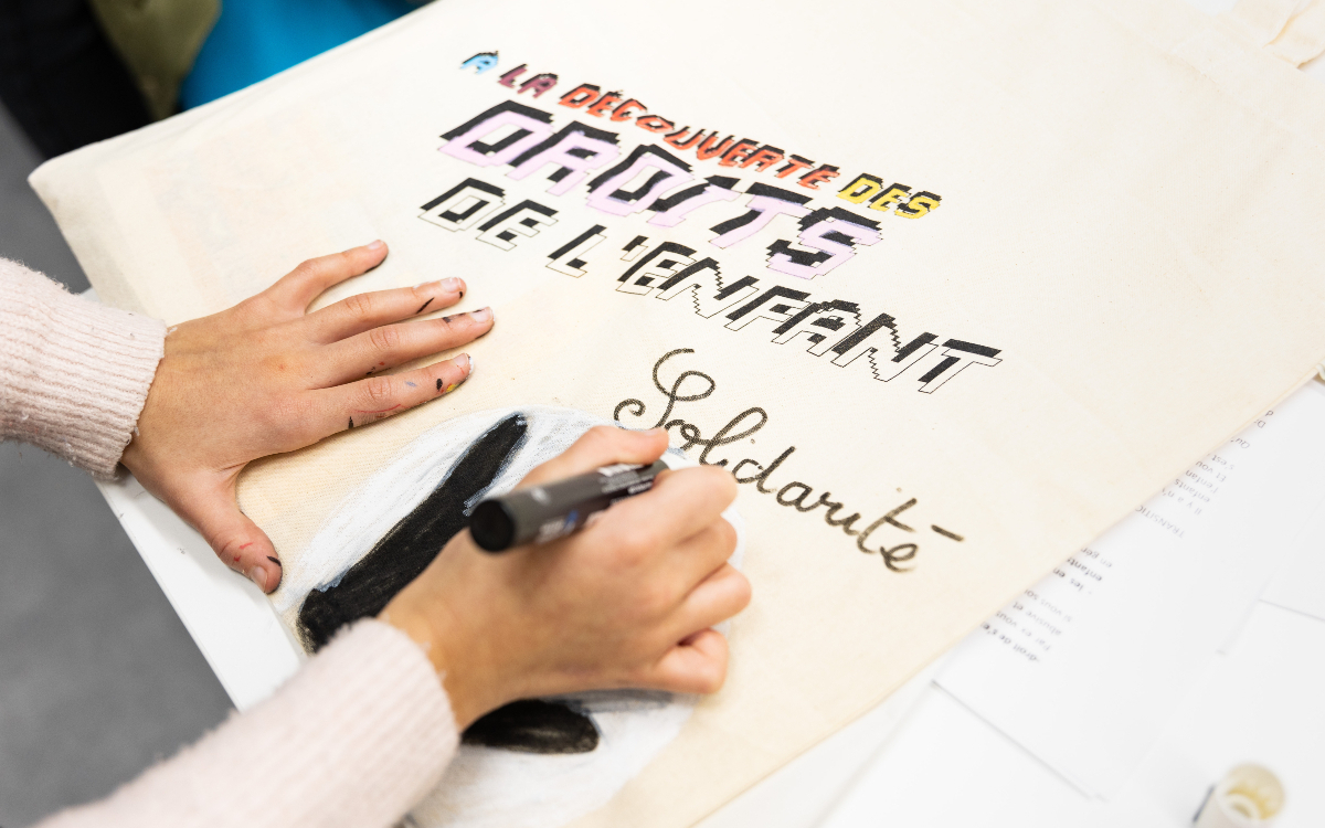Un enfant créant une affiche droits de l'enfant.