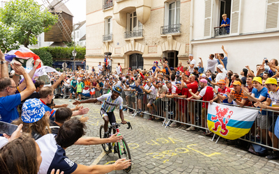 Un cycliste check la main d'un spectateur, lors du cyclisme sur route à Montmartre. 