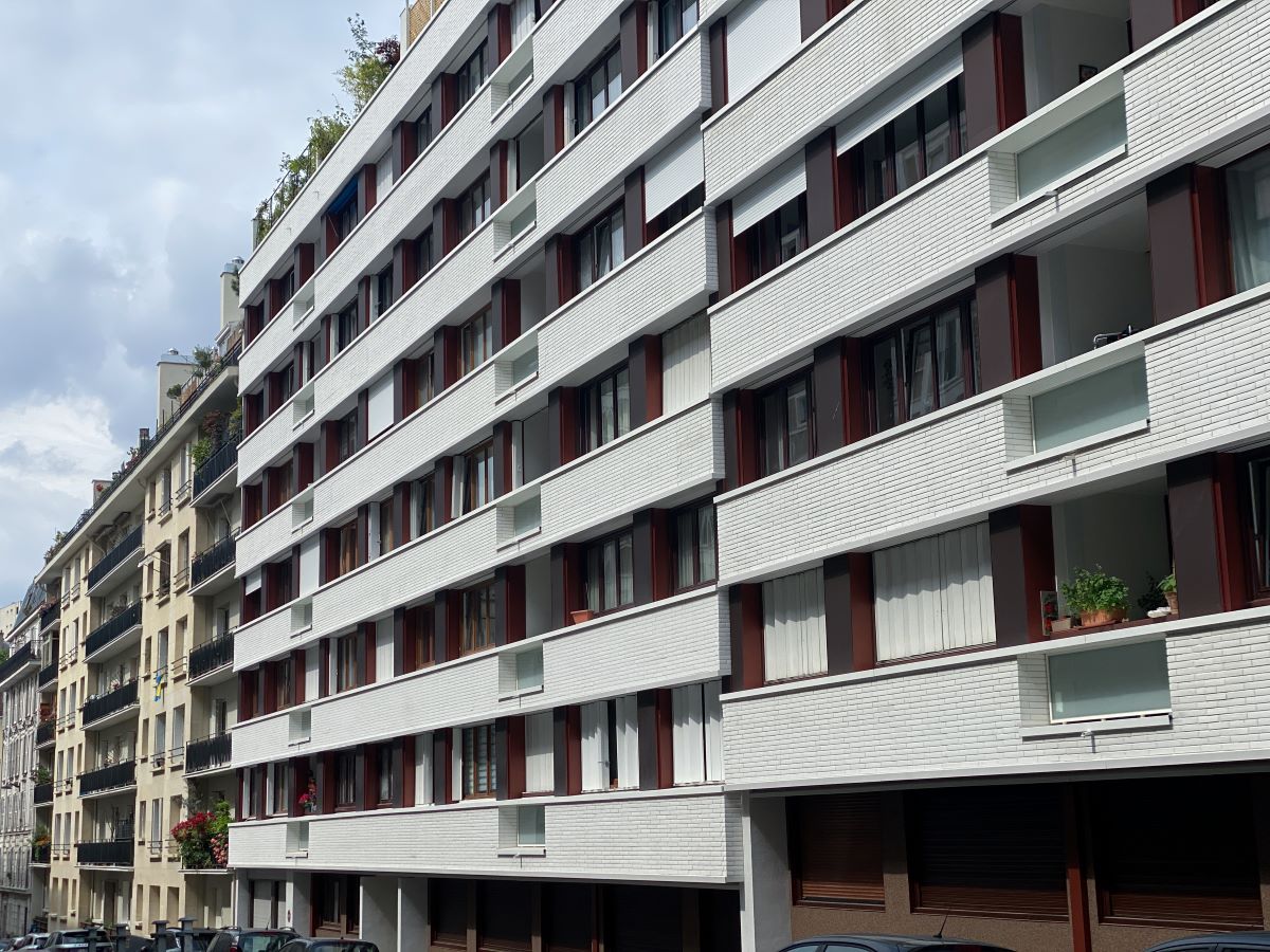 Un immeuble vue depuis la rue à la façade blanche, qui a été rénovée récemment