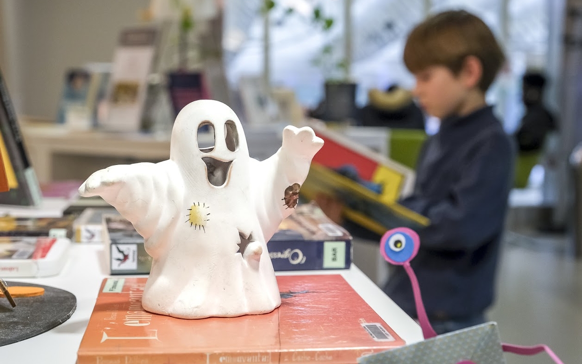 Une figurine installée près de livres, représente une petit fantôme rigolo !