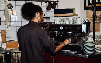 Commerçant de dos en train de préparer un café.