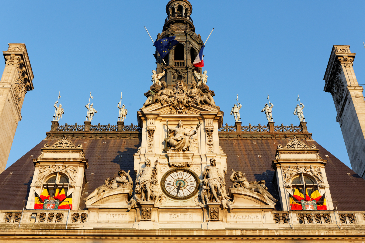 Des drapeaux belges sont suspendus sur la façade de l'Hôtel de Ville. 