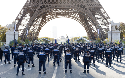 Groupe de policiers municipaux de dos sous la Tour Eiffel