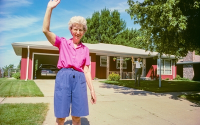 Femme et homme saluant les passants devant leur maison