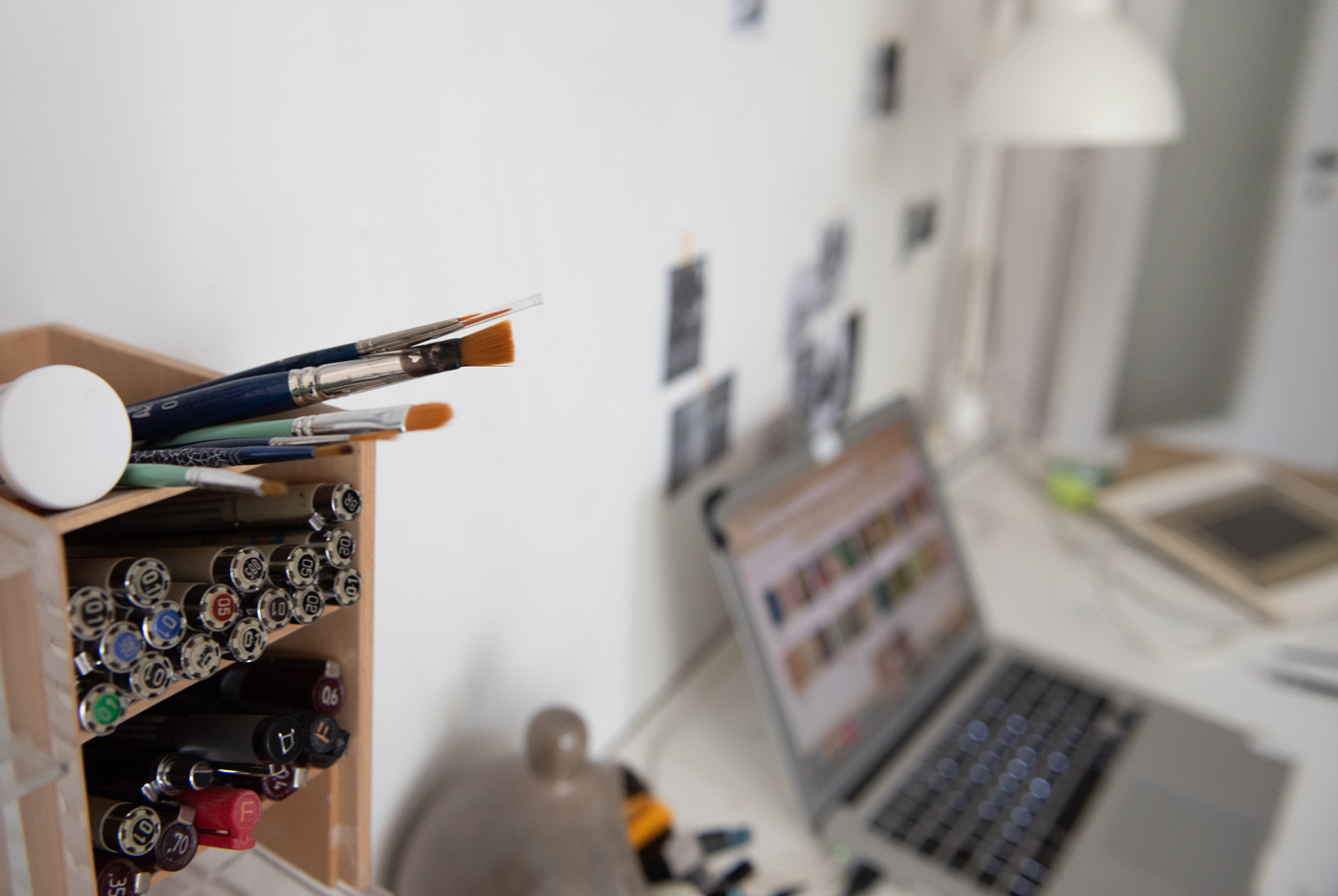 L'espace de travail de Pia-Melissa Laroche, comprenant son bureau, son ordinateur, ses crayons et pinceaux.