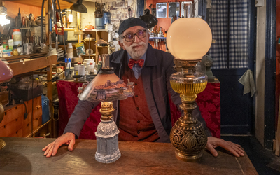 Un monsieur entouré de lampes anciennes