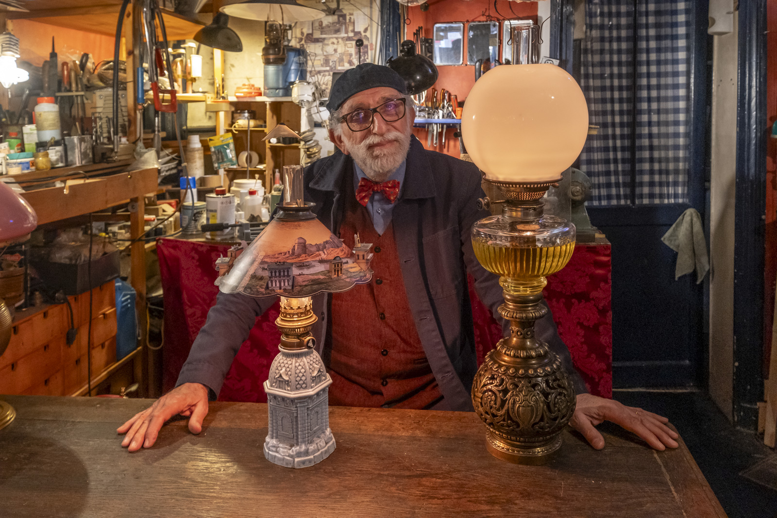 Un monsieur entouré de lampes anciennes