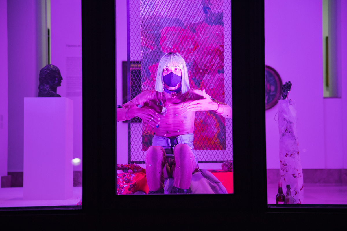 Gaelle Choisne propose des scènes dansées derrière les vitres du Musée d’Art Moderne de Paris, visibles depuis la rue. En mélangeant les cultures du Ballroom et du Voguing et en troquant le quartier rouge pour un musée rose, l’artiste place le vivant à l’honneur.