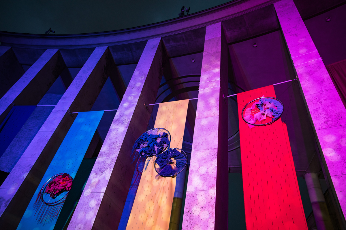 Sheila Hicks, grande dame des symphonies textiles, investit les colonnades situées entre le Musée d’Art Moderne de Paris et le Palais de Tokyo. Des comètes se meuvent pour nous rappeler notre présence passagère dans notre monde.