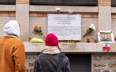 Deux personnes viennent se recueillir devant une plaque commémorative en hommage aux victimes des attentats du 13 novembre 2015