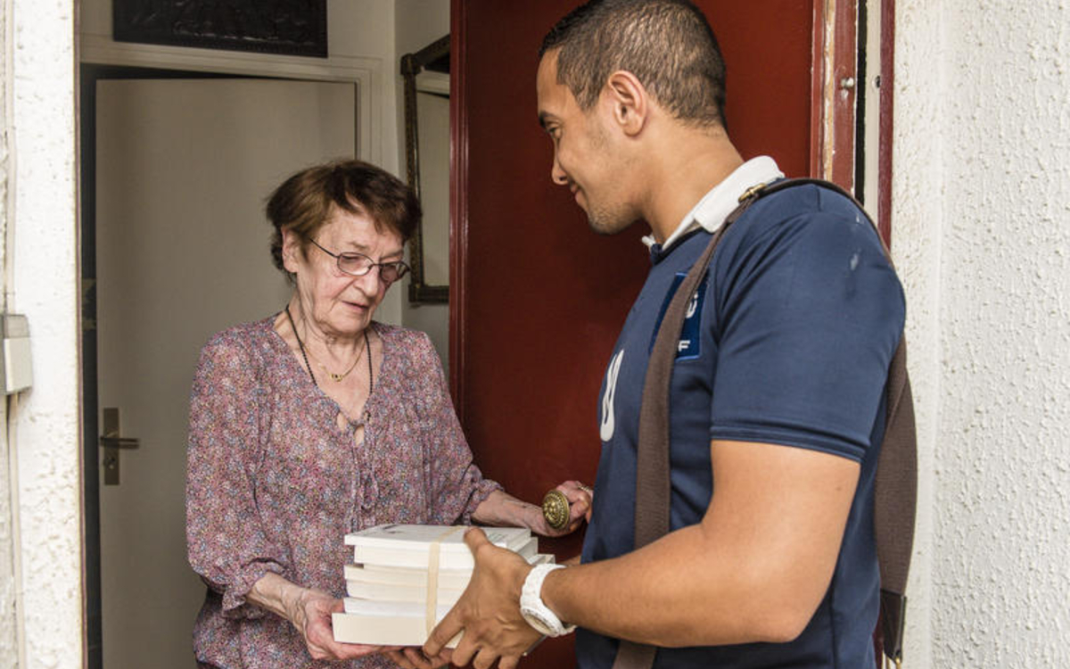 une homme donne des livres à une personne âgée