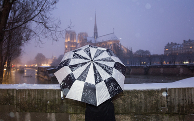 Une passante regarde Notre-Dame sous la neige 