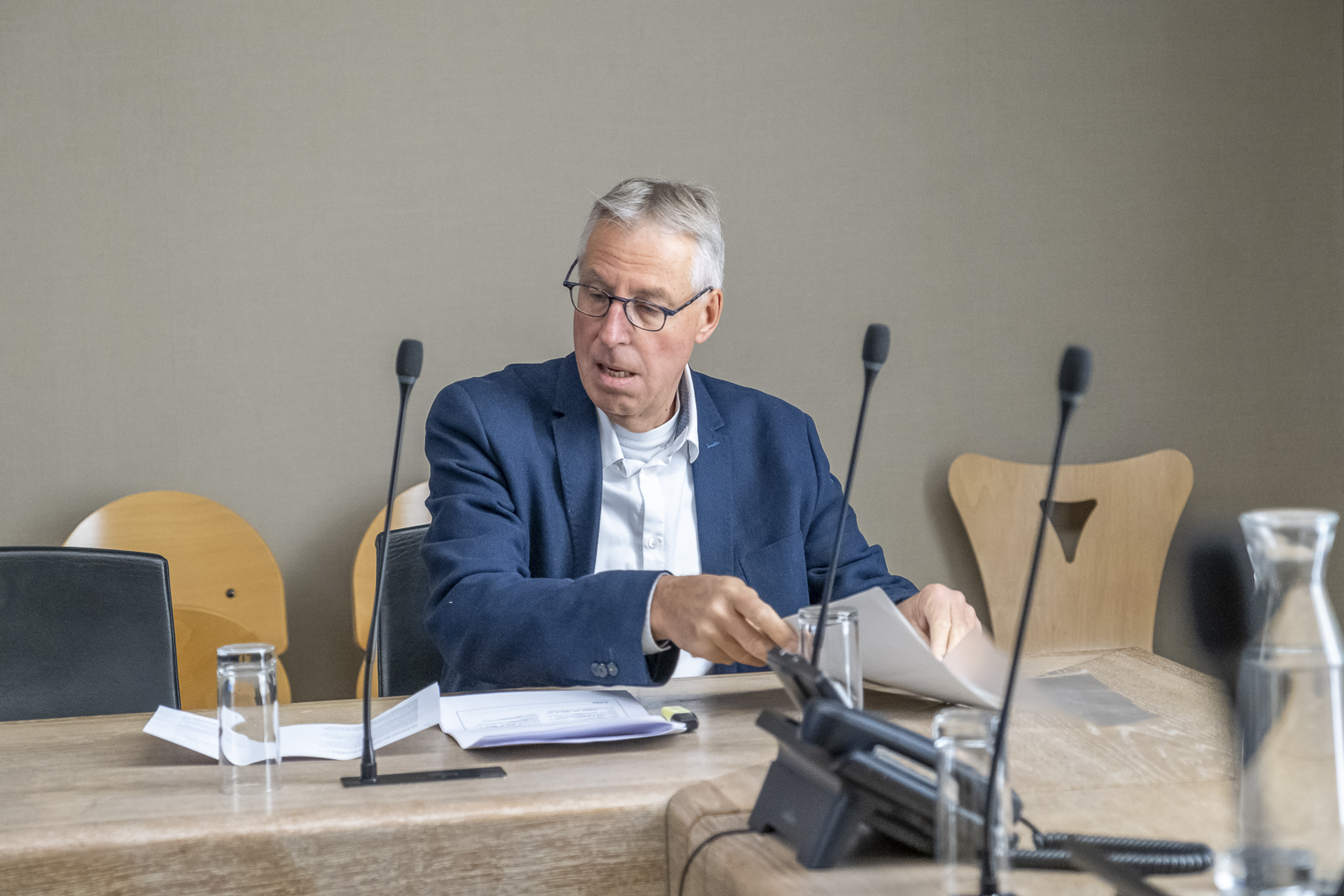 Portrait de Jürgen Bachmann, assis en train de trier ses dossiers