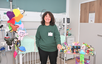 Marie France Carasse directrice du centre de loisirs hospitalier Robert Debré entourée de jouets devant un lit d'enfant