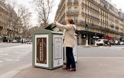 Une femme jette un sac de déchets alimentaires dans un trilib'