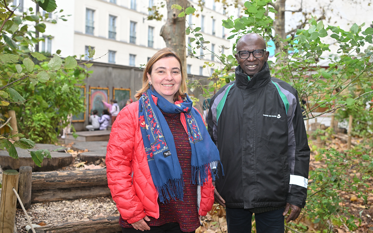 La responsable du pôle local nature et environnement du 20e pose avec un agent technique dans une cour oasis