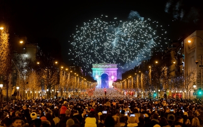 L'Arc de Triomphe de nuit, avec la foule regardant un feu d'artifice